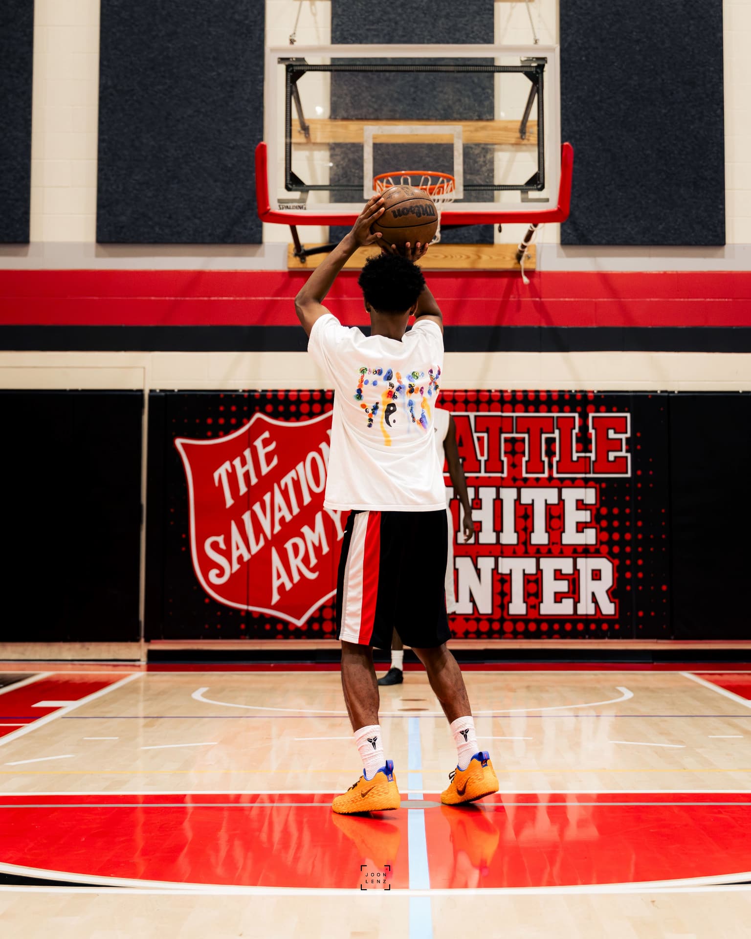 A young player squaring up for a set shot on a community-center court.