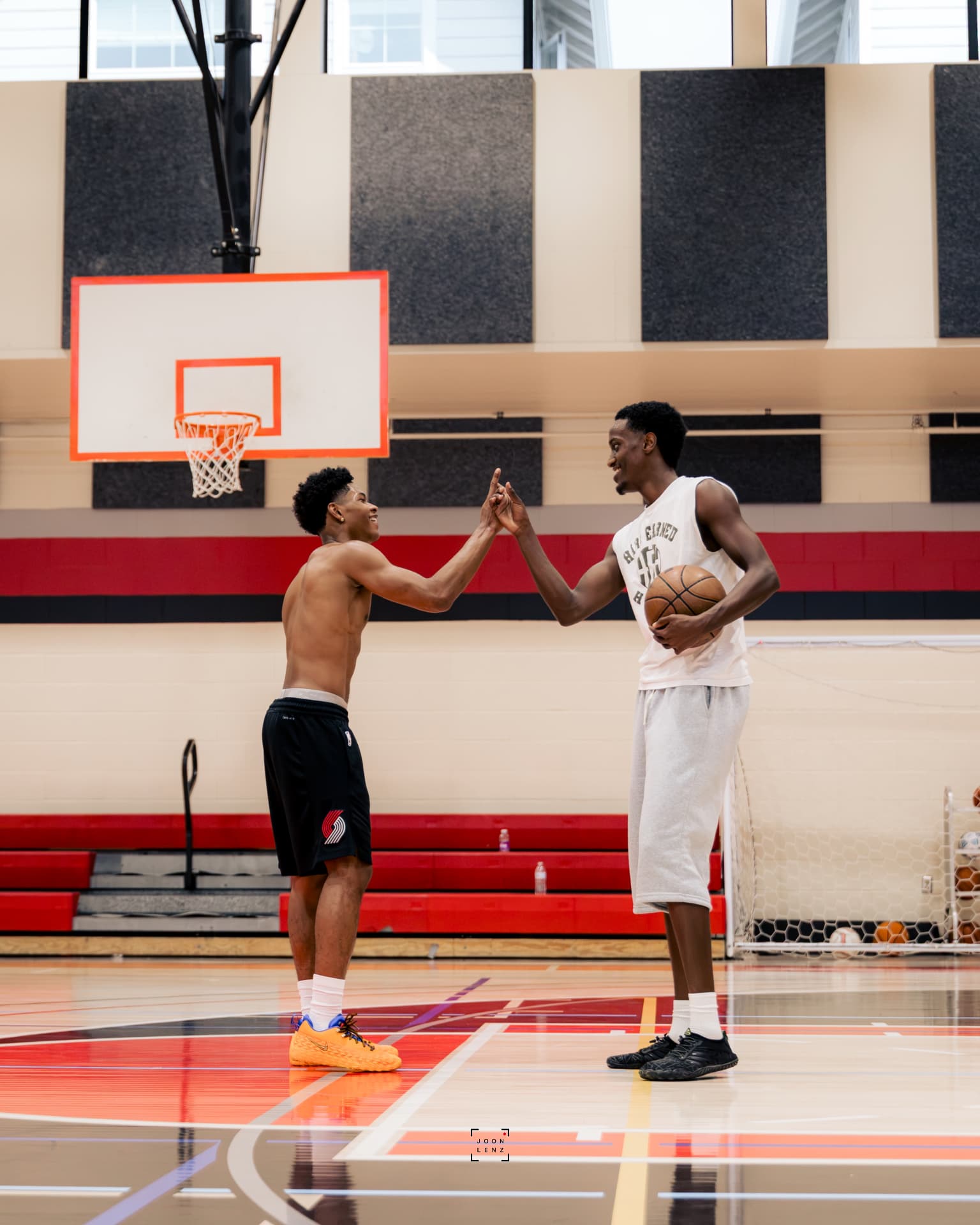 A coach and an athlete sharing a high five at center court after a rep.